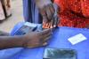 A Mercy Corps team member assists an e-voucher recipient with a digital identity process, increasing security and efficiency.