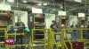 three workers assembling refrigerators 