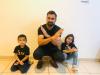 Man and two children in black t-shirts crossing their arms