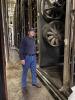 Plant Manager Bill Boula stands in front of new energy efficient fans being installed