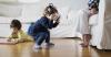 Children playing with VR headset and tablet in front of parent