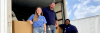 Three Cisco volunteers standing in the back of a box truck