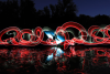 artistic image of red swirls and person in the dark