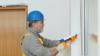 Worker applying caulk to a window.