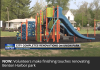 A playgound with slides, climbing walls in a park, houses in the far background