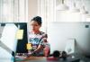 Woman seated at her desk behind a computer monitor.