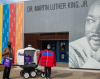 People out side of school holding up donated coats and FedEx cares bags