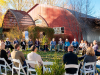 People sit outside in chairs arranged in a circle