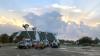 The sun shines behind clouds overlooking the University Center and bucket trucks at Southeastern in Hammond, Louisiana