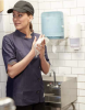 Woman drying her hands using a Tork Reflex dispenser.