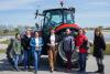 Women students stand in from of a tractor