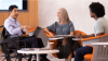 three people sitting around a small table