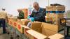 volunteers pack boxes with food