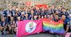 Large group of people with LBGTQ+ Flag and Gay Games Flag