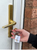 hand holding key with micro rainbow logo in front of an exterior door