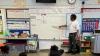 Black, male teacher using whiteboard in a classroom