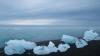 chunks of ice on a beach with open water in the background